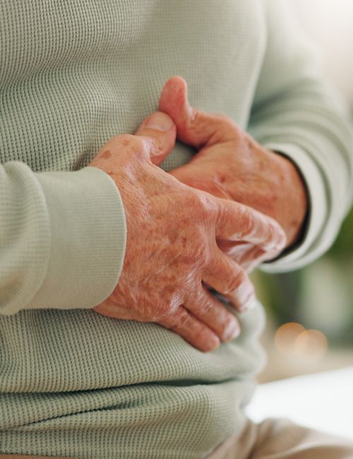 an older gentleman holding his guy from indegestion