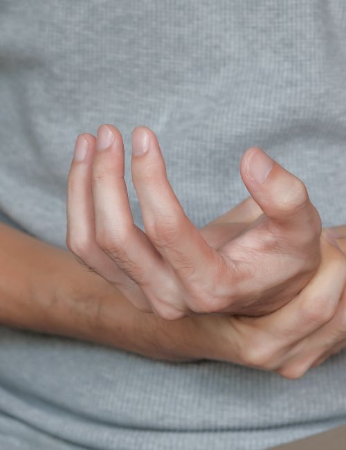 a person holding their wrist because of joint pain